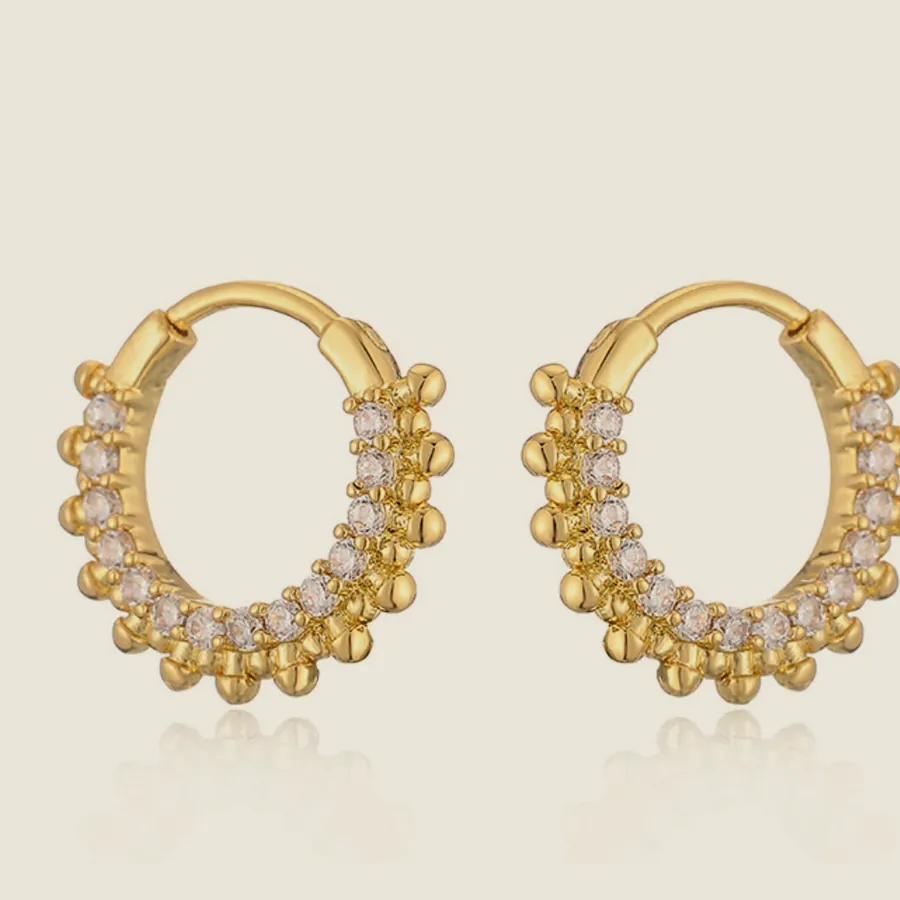 Gold-tone oval hoop earrings with small pearls along the inner rim.