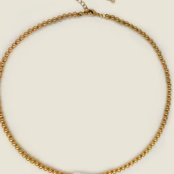 Gold-tone round-link chain necklace with an elongated pearl mounted at the front.