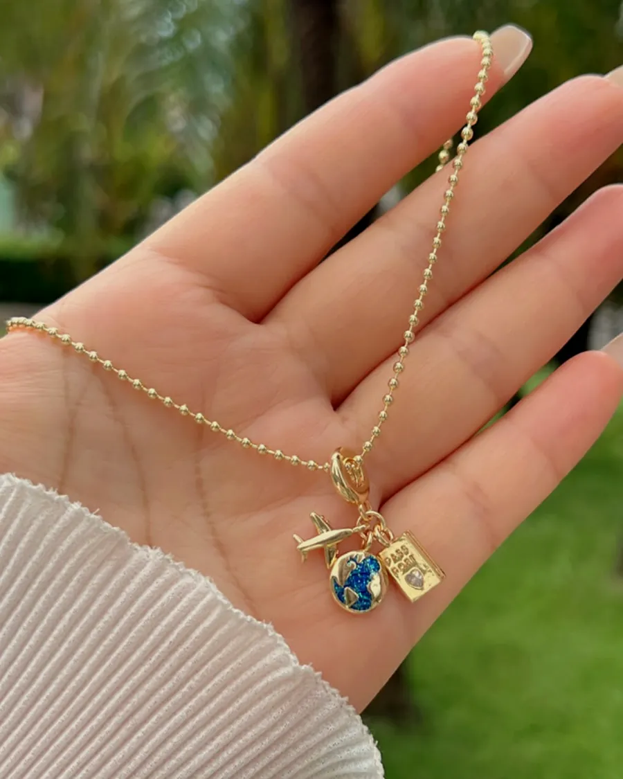 Una cadena con dijes sostenida en la palma de la mano.