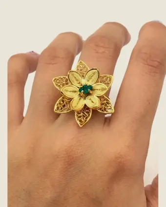Anillo de flor de filigrana puesto en la mano.