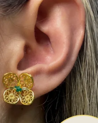 Filigree flower earring worn on the ear.