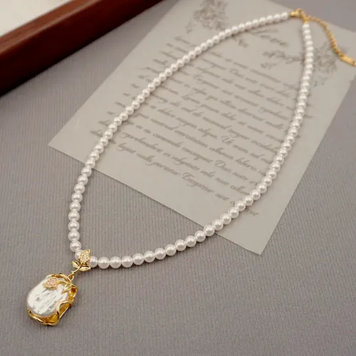 Necklace of small freshwater pearls finished with a large baroque pearl in a gold-tone claw.