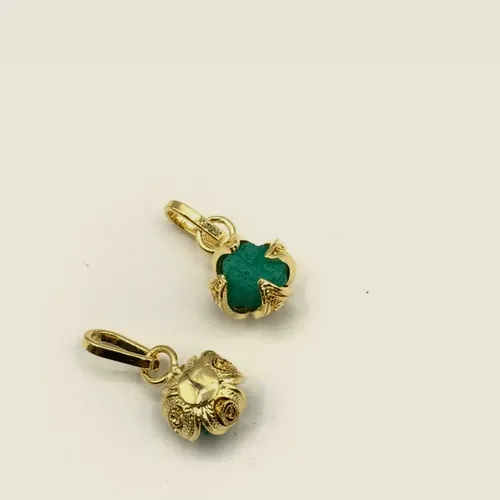 Two clover pendants, one with green raw emerald and one plain gold tone.