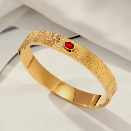 Textured bangle with a red crystal.