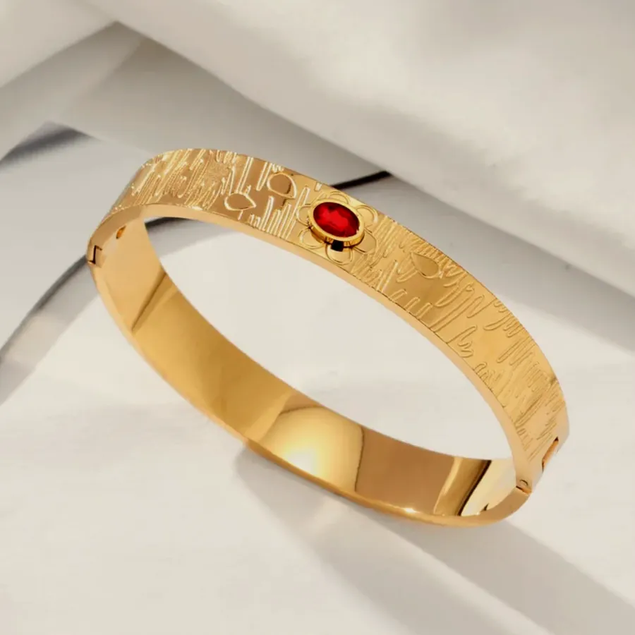 Textured bangle with a red crystal.
