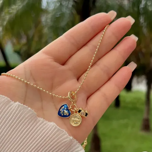 Necklace with a blue heart, held in the hand.