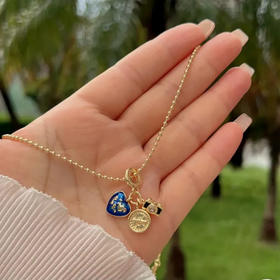 Necklace with a blue heart, held in the hand.