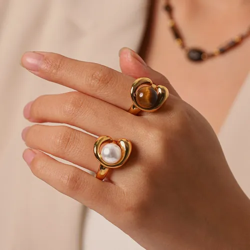 Gold rings with stone spheres, worn.