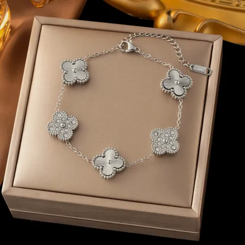 Gold bracelet with white clovers.