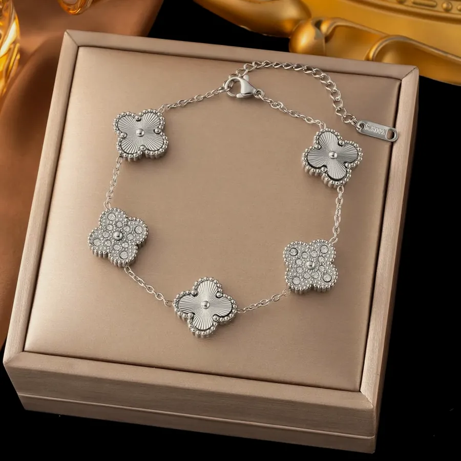 Gold bracelet with white clovers.