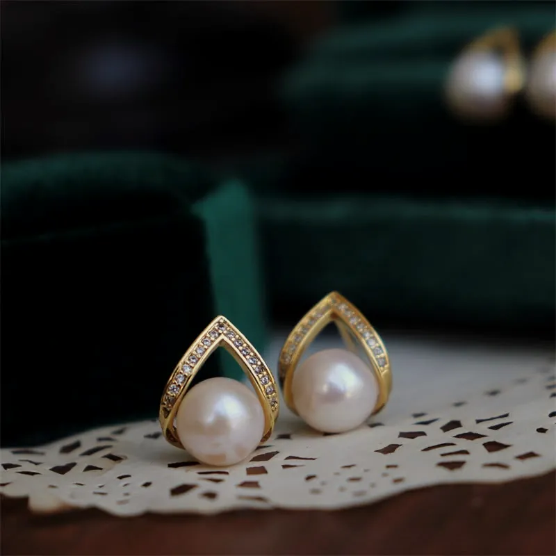 Pearl studs with a gold V.