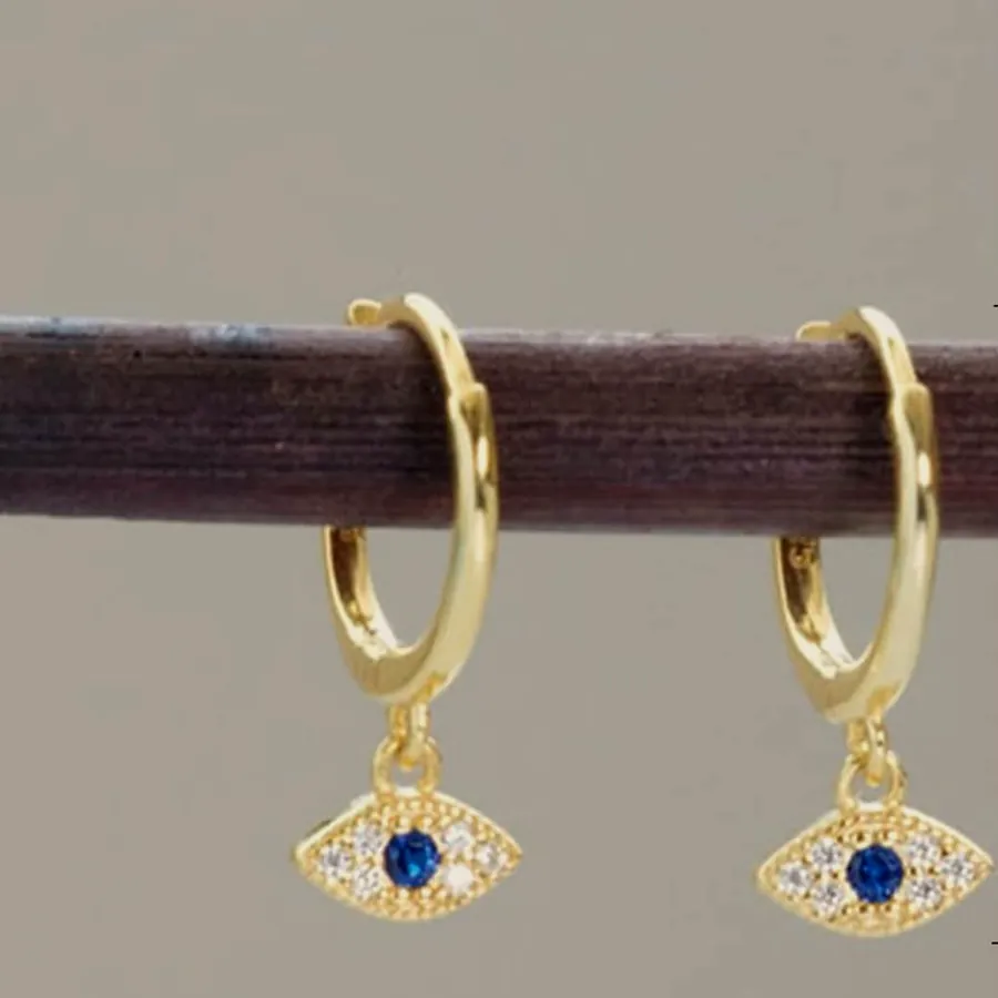 Gold hoops with a blue evil eye charm.