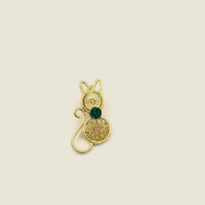 Filigree cat pendant with a raw emerald.