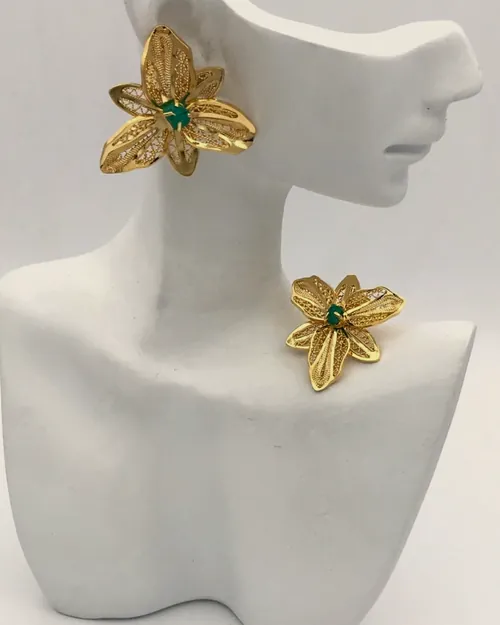 Hammered flower earrings on a white bust.