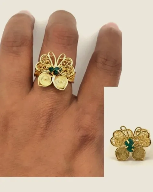 Filigree butterfly ring worn on the hand.