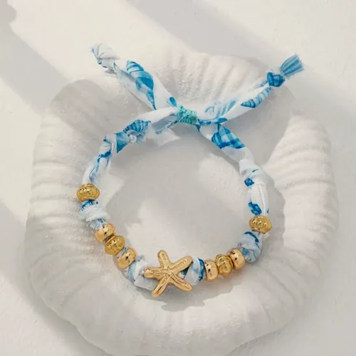 Blue fabric bracelet with a gold starfish.