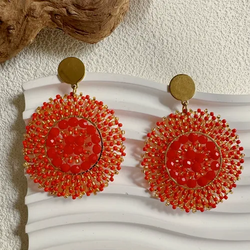 Red woven disc earrings in Miyuki beadwork on a white surface.