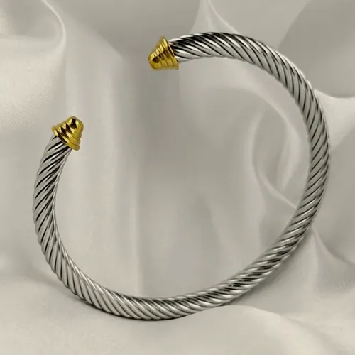 Silver cable cuff with gold tips.