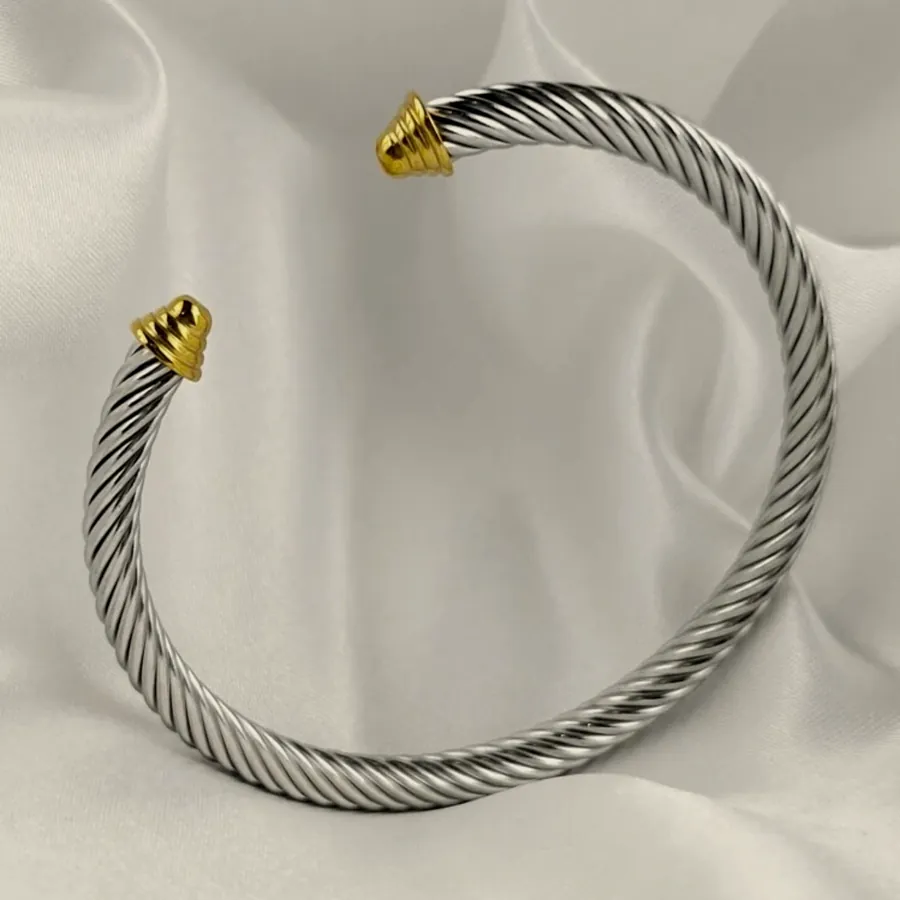 Silver cable cuff with gold tips.