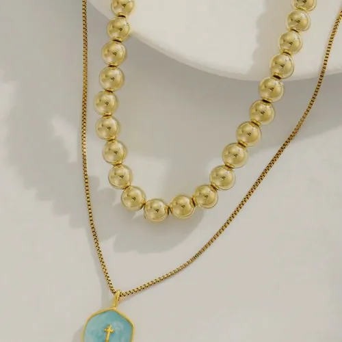 Layered necklace with a blue enamelled disc.
