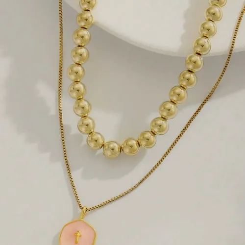 Layered necklace with a pink enamelled disc.