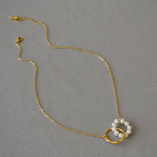 Pearl circle necklace on a grey background.