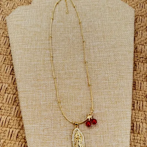 Medal necklace with a garnet bead, on a bust.