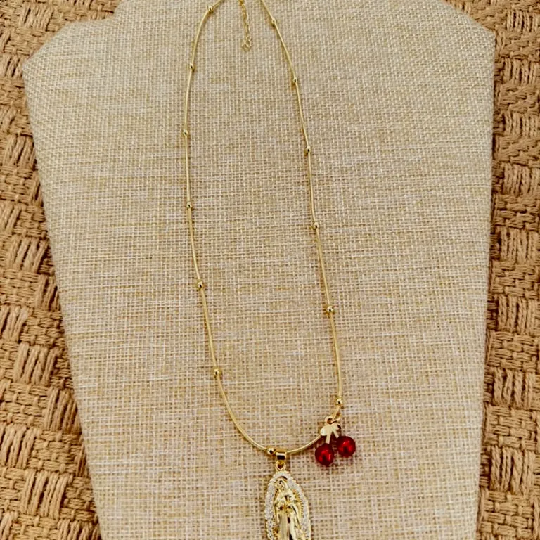 Medal necklace with a garnet bead, on a bust.