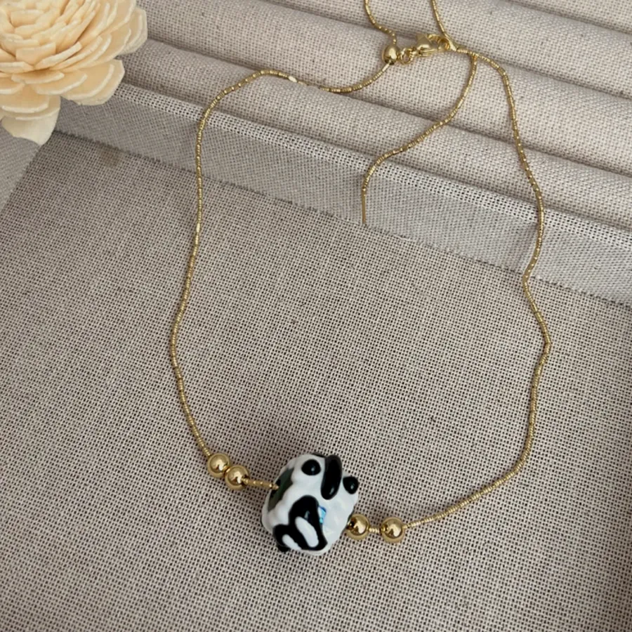 Gold bead chain necklace with a cow-print bead.