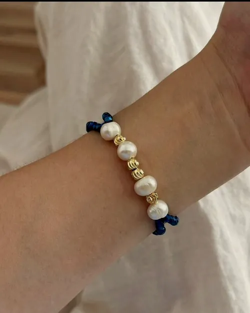 Pearl bracelet with blue beads, worn.