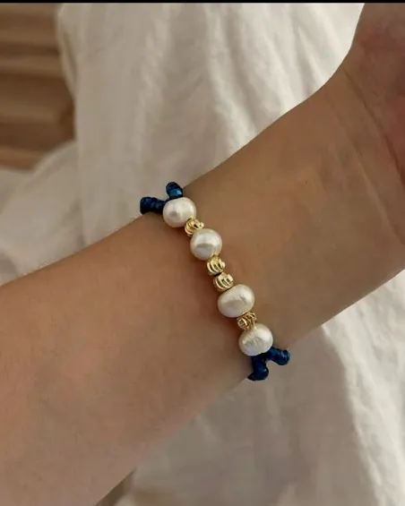Pearl bracelet with a cow-print bead, worn.