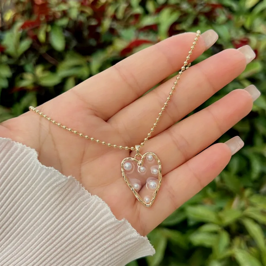 Pearl heart necklace, held in the hand.