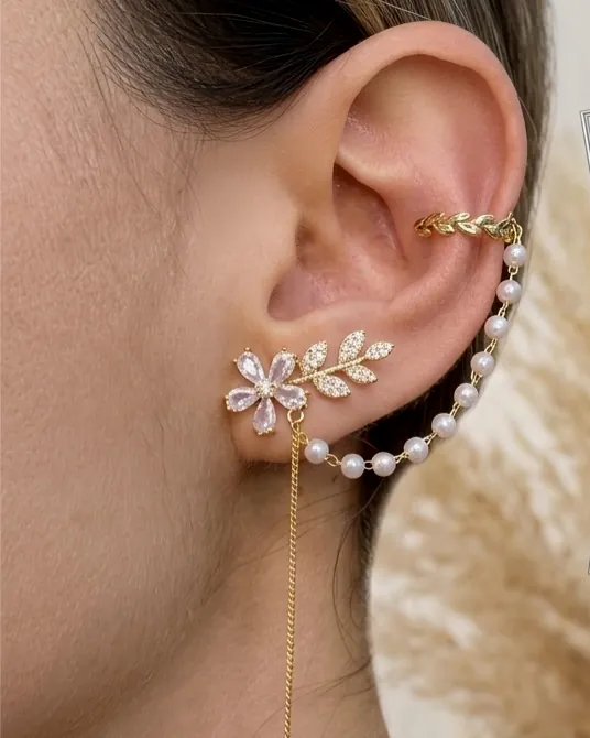Flower earrings, a pearl hoop and an ear cuff worn on the ear.
